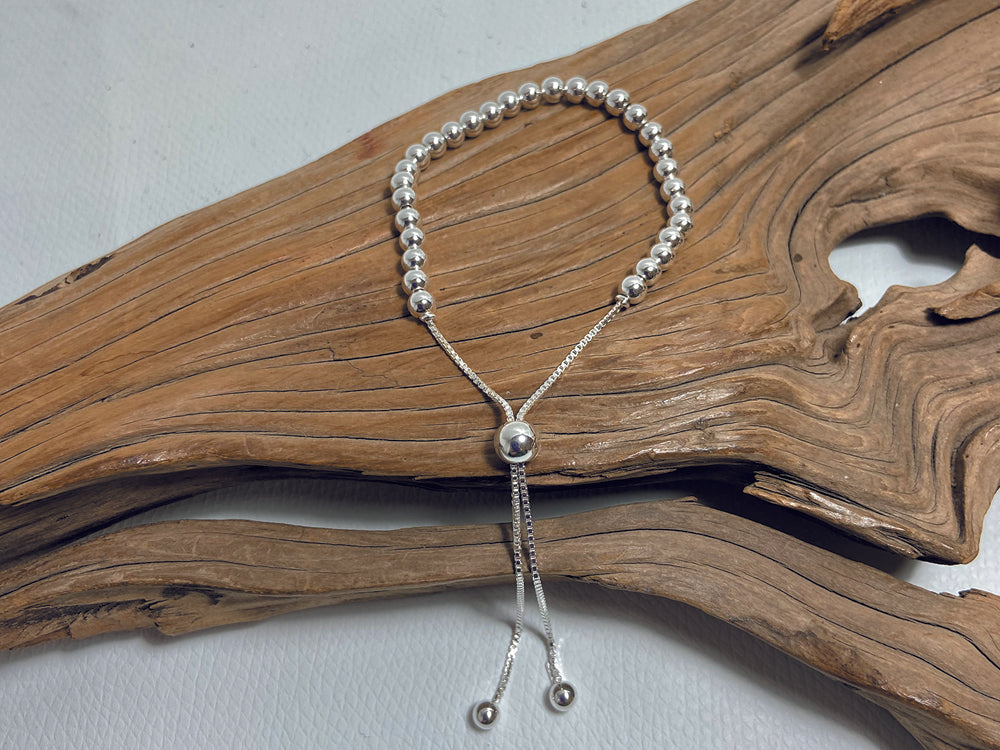 The sliding bead on this sterling silver bracelet means it can be adjusted to suit all different wrist sizes. Each bead measures about 3mm. 925 Canterbury