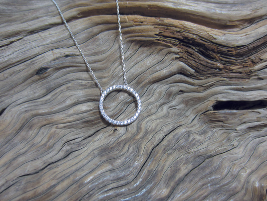 A simple, sterling silver and cubic zirconia set 19mm diameter circle hanging from simple chain which can be worn at either 41 or 45cm. This piece is rhodium plated to reduce the need for cleaning.