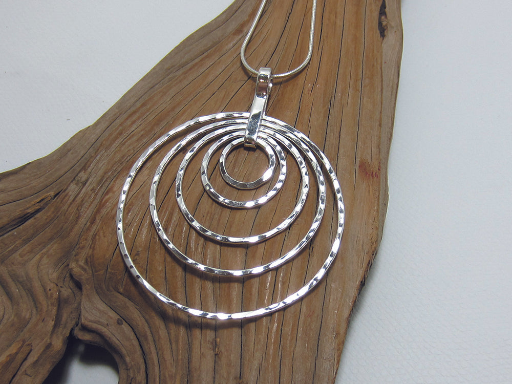 A statement, sterling silver pendant which is 52mm across and catches the light beautifully with it's hammered finish. It is shown here in a fine snake chain. 925 Silver Canterbury