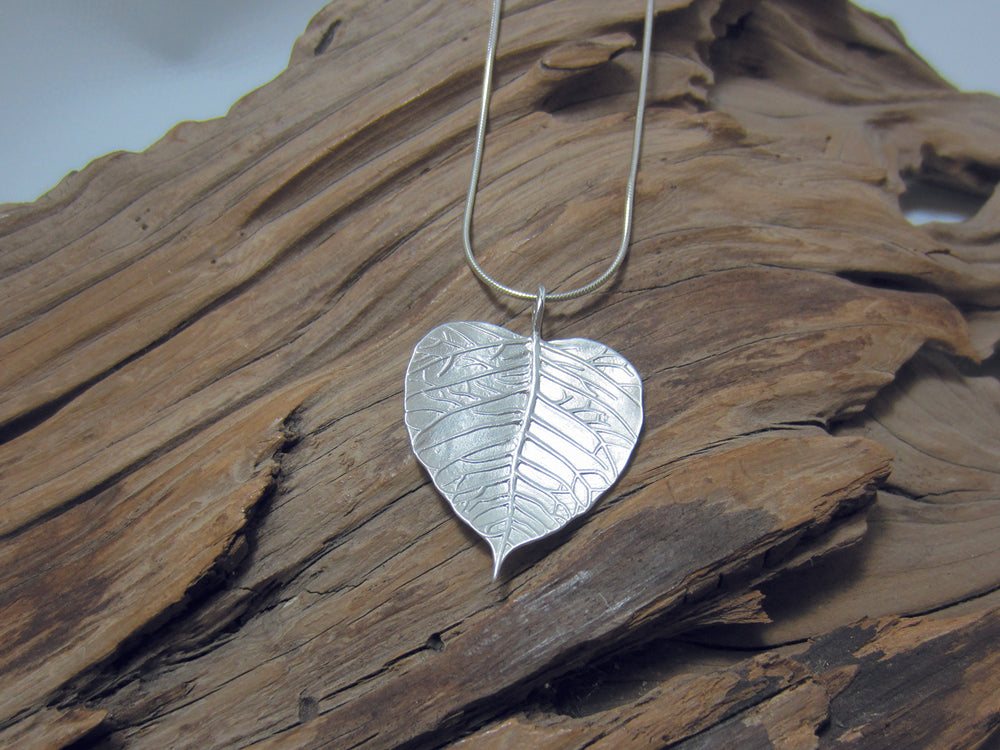 Nicely detailed, matt finish sterling silver leaf shaped pendant, shown here on a fine snake chain. It measures 28mm across and 40mm high including the bail. 925 Silver Canterbury