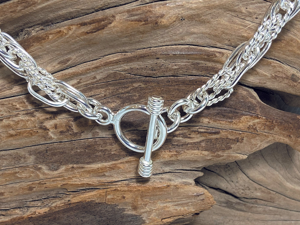 An unusual, sterling silver chain made up of interlinking plain and twisted links. The necklace is 18" long and weighs ajround 41 grams. 925 Silver, Canterbury