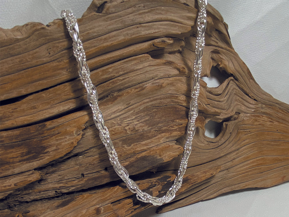 An unusual, sterling silver chain made up of interlinking plain and twisted links. The necklace is 18" long and weighs ajround 41 grams. 925 Silver, Canterbury