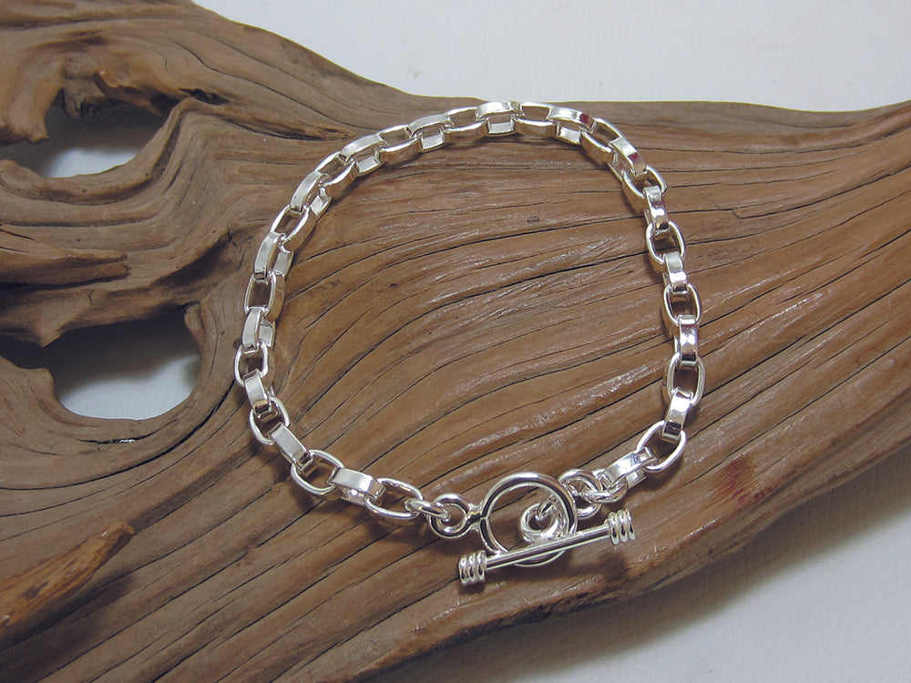 Stylish, sterling silver squared-off belcher chain bracelet with a t-bar fastener. It is 7.5" long and weighs around 13 grams. It is stamped with a full set of UK Hallmarks. 925 Silver Canterbury