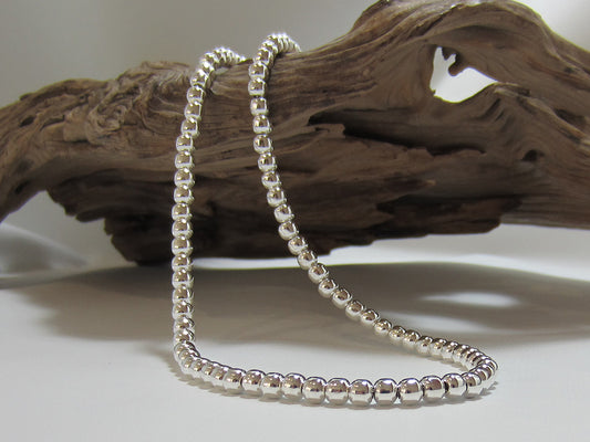 Sterling silver beads strung on a silver chain. The necklace measures 17" or 43 cms long and has a t-bar fastener. It weighs 34 grams so carries a full set of UK Hallmarks. 925 Silver Canterbury