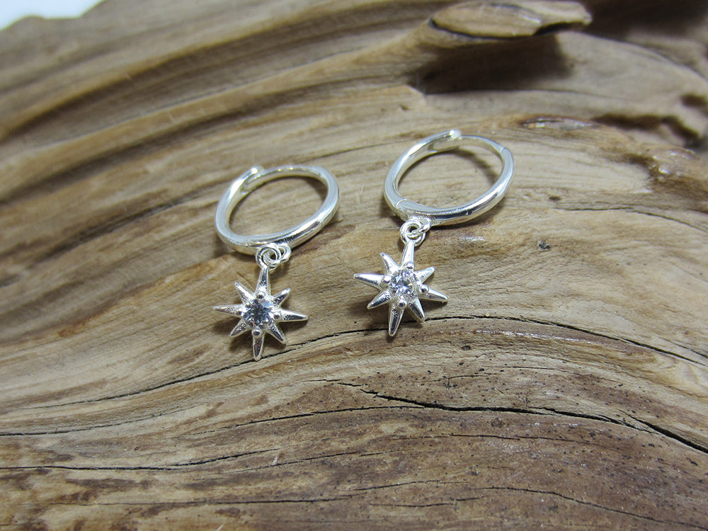 12mm sterling silver hinged huggie hoops, each with a star charm set with a single cubic zirconia. 925 Canterbury